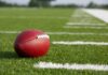 Football resting on a grassy field.