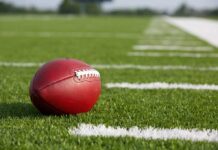 Football resting on a grassy field.