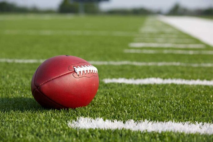 Football resting on a grassy field.