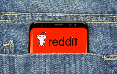 shutterstock_1422504605.jpg Phone displaying Reddit logo in pocket of blue jeans.