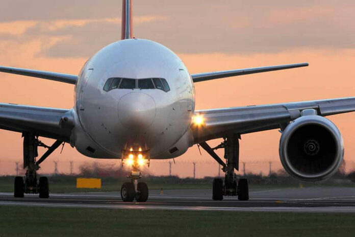 555148006 Airplane on runway during sunset.