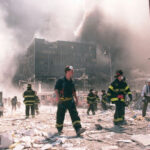 16 Students KILLED – Scandal Erupts Firefighters walking through debris near a heavily damaged smoking building