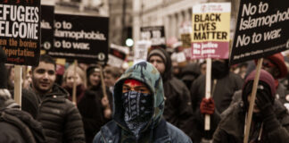 A diverse group of protesters holding signs during a march for social justice