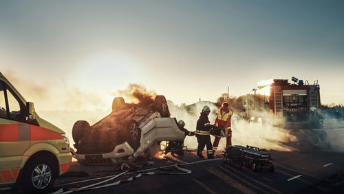 shutterstock_1721662801 Firefighters responding to a car crash at sunset.