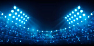 Football stadium under bright lights at night.