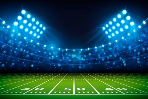 shutterstock_2200701739 Football stadium under bright lights at night.