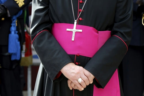 shutterstock_2222602787 Close-up of a cleric with cross necklace.