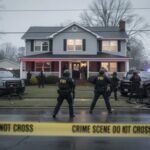 Gay Icon ARRESTED — Disturbing Trafficking Charges… FBI agents at a crime scene outside a house with police vehicles and caution tape