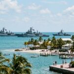 DRONE SWARM Aimed at Florida—Intel Leaked… A fleet of naval ships sailing in the ocean near a tropical shore