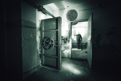 Abandoned,Prison,In,Underground,Bunker.,Ghost,Of,Prisoner.,Ex,Soviet A dark, abandoned room with a mysterious figure in the background