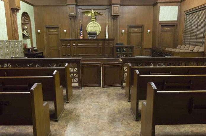 Empty courtroom with wooden benches and judges bench.