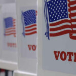 Voting booths with American flags and VOTE signs
