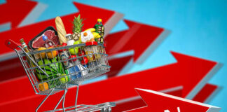 Shopping cart filled with groceries atop Inflation arrow.