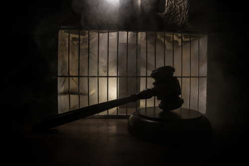 Execution,With,Lethal,Injection,Concept.,Death,Penalty,Lethal,Injection,Table A gavel placed on a wooden surface in front of a barred cage with a smoky background