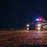 Probation FAILURE Ends A Father’s Life Police car with flashing lights parked in a dark urban area