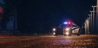 Police car with flashing lights parked in a dark urban area