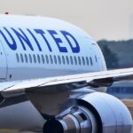 Violent Outburst Derails Transpacific Flight Flight attendant closing an overhead bin on airplane.
