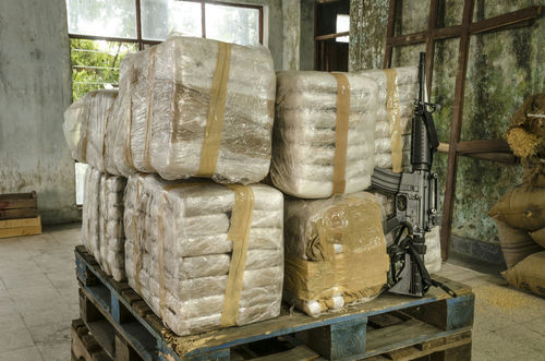 shutterstock_399522988 Pallet with large wrapped packages and an assault rifle.