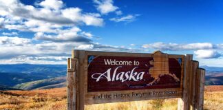 Welcome to Alaska sign in a mountainous landscape