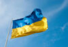 Ukrainian flag waving against blue sky.