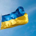 Wartime Shake-Up: Energy Boss Takes Helm Ukrainian flag waving against blue sky.