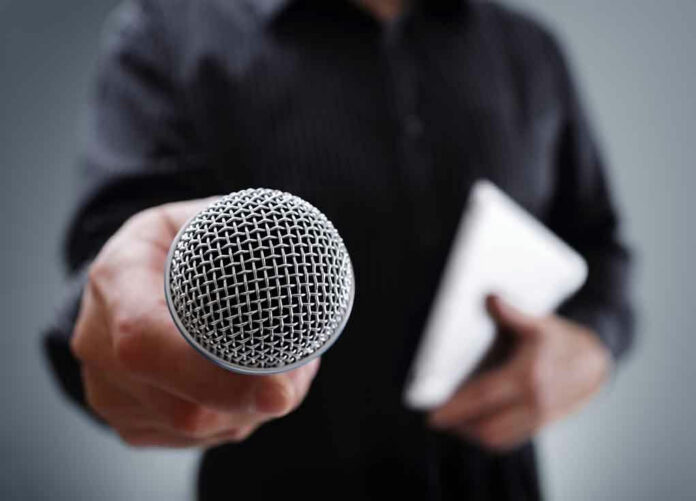 379587706 Person holding a microphone and a tablet.