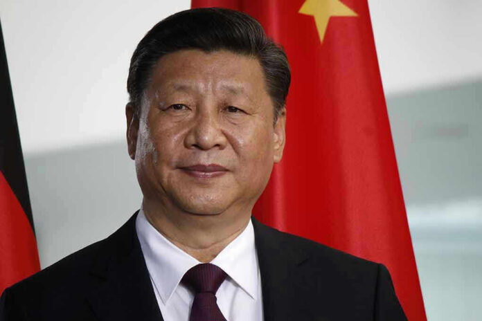 677148799 Man in suit standing before Chinese flag.