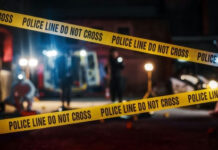Yellow police tape at a nighttime crime scene.