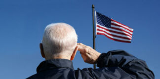 Elderly man saluting the American flag