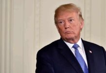 America First Crushes Career Diplomats man in suit with blue tie looking to the side