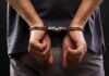 person with hands cuffed behind back