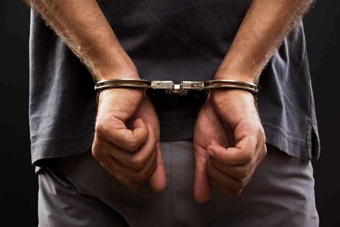 shutterstock_109783121 person with hands cuffed behind back