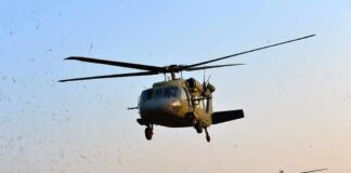 Military helicopters flying low over a dry landscape
