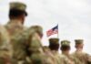 CENTCOM Moves: Ships Redirected U.S. flag flying above a formation of soldiers in uniform