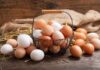 Basket of brown and white eggs on rustic wooden table