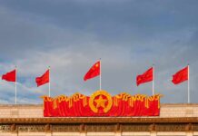 Monster Refill Ship Shadows U.S. Carriers Chinese flags atop a decorated building facade