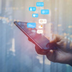 Parliament Greenlights Chat Scans Again A hand holding a smartphone with social media notifications displayed above it