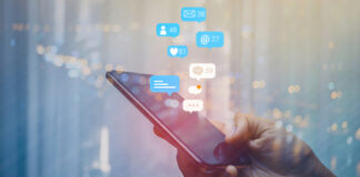 A hand holding a smartphone with social media notifications displayed above it
