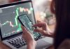 Congress Trading Game OVER — Families Included person analyzing stock charts on smartphone and laptop