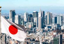 Japanese flag waving with modern city skyline in background