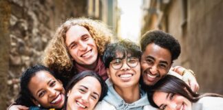 Group of friends smiling closely together outdoors
