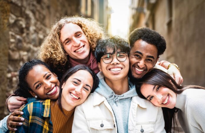 Multi,Racial,Guys,And,Girls,Taking,Selfie,Outdoors,With,Backlight Group of friends smiling closely together outdoors