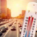 Heat Emergency Showdown: 78 Or Else? Thermometer displaying high temperature with a busy road in the background