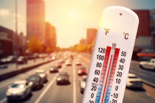 Thermometer,In,Front,Of,Cars,And,Traffic,During,Heatwave Thermometer displaying high temperature with a busy road in the background