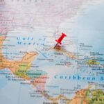Florida’s Backyard Bugged — Guess Who? Cuban license plate with flag beside maracas and cigars