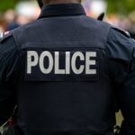 Closed-Door Vote, Million-Dollar Cop Payday Back view of a police officer in uniform at a public event