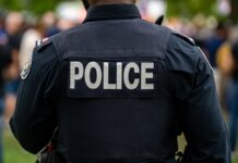 Closed-Door Vote, Million-Dollar Cop Payday Back view of a police officer in uniform at a public event
