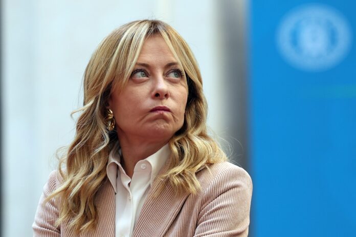 Rome,,Italy,,February,5,,2026:,Giorgia,Meloni,Awaits,The,Arrival Man in suit speaking at podium with international flags behind