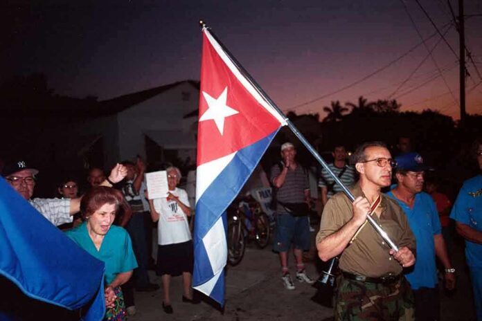 shutterstock_37307824 A group of people participating in a protest march holding a Cuban flag