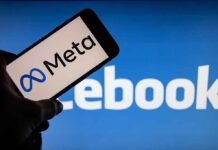 Meta logo on phone, Facebook logo in background.